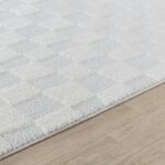 Tapis blanc texturé sur parquet clair.