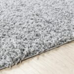 Tapis gris moelleux sur parquet.