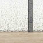 Règle mesurant épaisseur d'un tapis blanc.