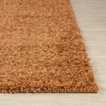Tapis moelleux marron sur sol stratifié.