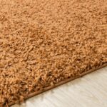 Tapis shaggy marron texture dense sur parquet