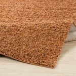 Tapis shaggy orange texturé sur plancher en bois