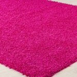 Tapis rose texturé sur plancher en bois