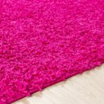 Tapis rose texturé sur plancher en bois.