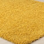 Tapis jaune moelleux sur parquet.