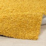 Tapis shaggy jaune sur plancher bois.