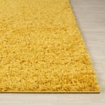 Tapis jaune moelleux sur sol stratifié.