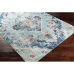 Tapis vintage floral sur plancher en bois.