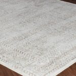 Tapis beige à motifs traditionnels sur sol.