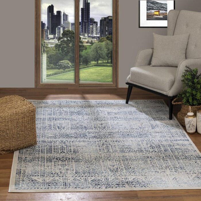 Intérieur avec tapis, fauteuil et vue urbaine.