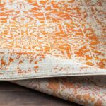 Tapis orange et gris à motifs.