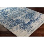 Tapis persan bleu et crème sur parquet.