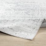 Tapis gris décoratif intérieur sur sol en bois.