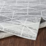 Tapis moderne gris sur plancher en bois.