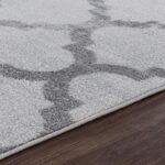 Tapis gris moderne sur plancher en bois.