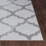 Tapis motif géométrique gris et blanc.