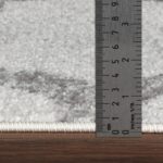 Règle métallique mesurant tapis épais.