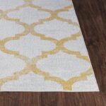 Tapis motif géométrique or et blanc.