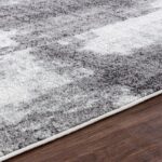 Tapis gris ombré sur plancher en bois.