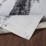 Tapis moderne noir et blanc sur parquet.