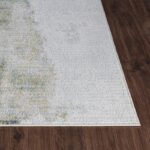 Tapis blanc motif floral sur parquet brun.