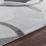 Tapis moderne gris sur sol en bois.