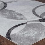 Tapis moderne gris avec motifs géométriques circulaires.