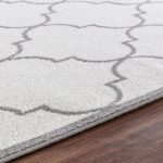 Tapis à motifs géométriques en gris et blanc.