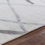 Tapis moderne gris sur plancher en bois.