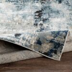 Tapis moderne bleu et gris sur sol en bois.