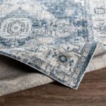 Tapis vintage bleu et beige sur plancher.