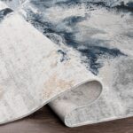 Tapis design bleu gris déroulé sur sol en bois
