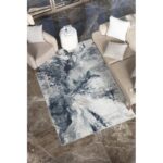 Salon moderne avec tapis abstrait et canapé beige.