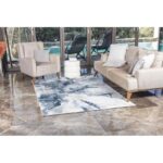 Salon moderne avec canapé, fauteuils et tapis design.