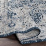 Tapis gris et bleu aux motifs orientaux.