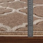 Mètre mesurant l'épaisseur d'un tapis beige.