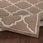 Tapis motif géométrique beige sur plancher bois.