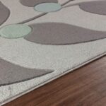 Tapis moderne motifs géométriques sur parquet brun.