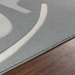 Tapis moderne avec détails géométriques sur parquet.