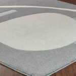Tapis moderne gris et blanc, design géométrique.