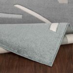 Tapis gris sur plancher en bois.