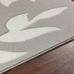 Tapis texturé gris, motif abstrait sur sol en bois