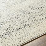 Tapis texturé beige et noir sur sol en bois