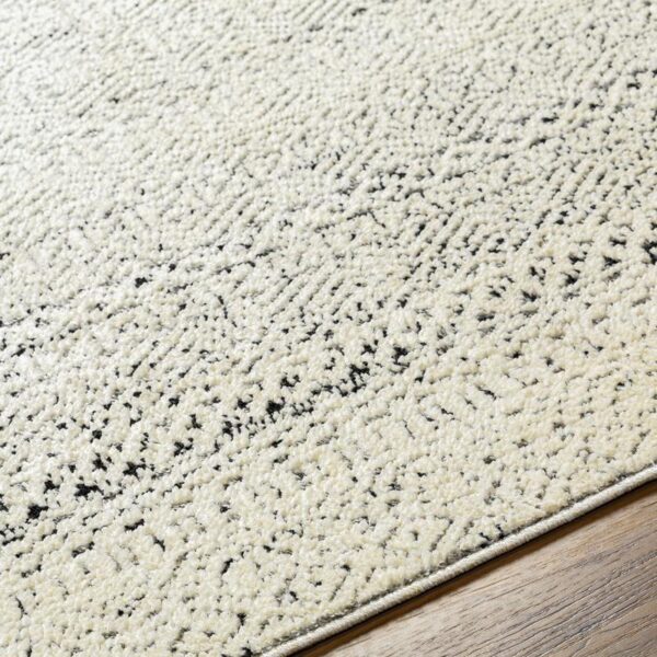 Tapis texturé beige et noir sur sol en bois
