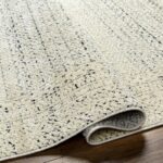 Tapis beige texturé sur plancher en bois.