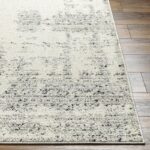 Tapis beige à motifs sur parquet.