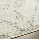 Tapis beige à motifs géométriques noirs.