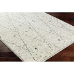 Tapis moderne beige à motif sur parquet.