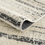 Tapis beige à motifs géométriques replié.