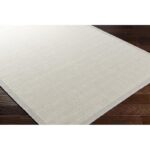 Tapis beige texturé sur plancher en bois.